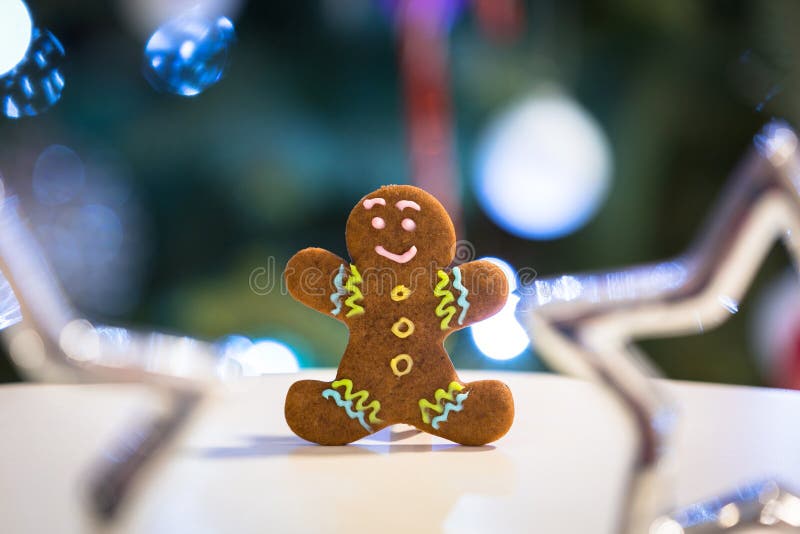 Gingerbröd på bordet och julgranslampa i bakgrunden royaltyfria bilder Gingerbröd på bordet och julgranslampa i bakgrunden royaltyfria bilder