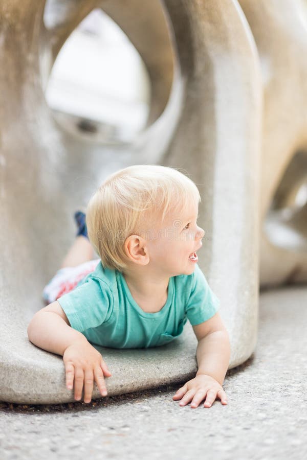 Giocare all'aperto. giochi per bambini in giardino scolastico o d'asilo. bambino attivo su scivolo di pietra immagine stock