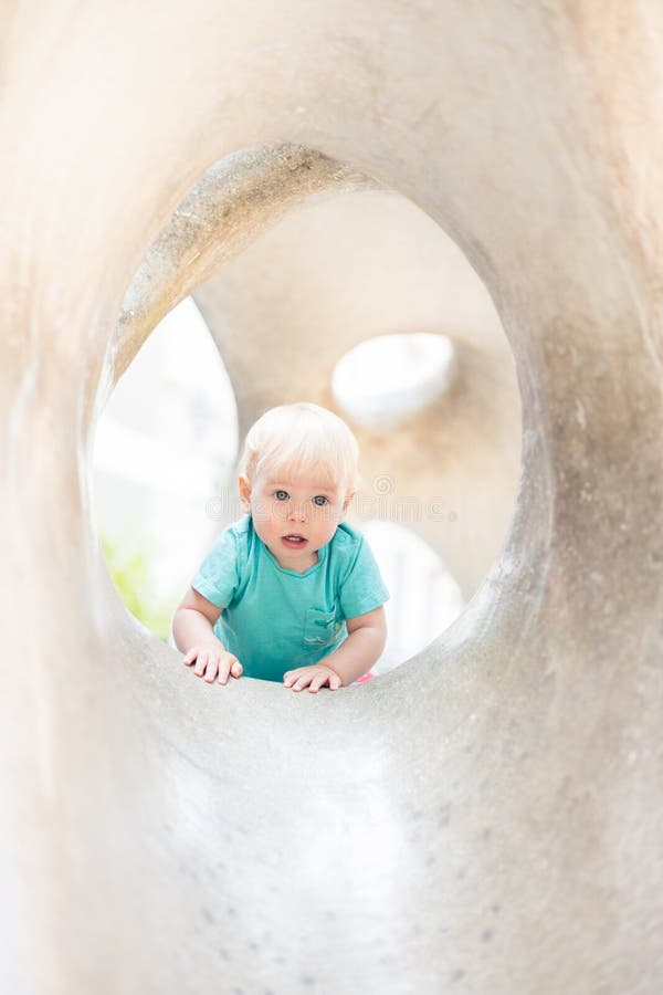 Giocare all'aperto. giochi per bambini in giardino scolastico o d'asilo. bambino attivo su scivolo di pietra immagine stock