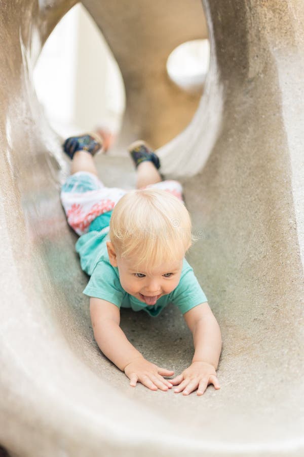 Giocare all'aperto. giochi per bambini in giardino scolastico o d'asilo. bambino attivo su scivolo di pietra immagini stock libere da diritti