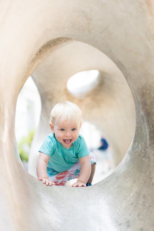 Giocare all'aperto. giochi per bambini in giardino scolastico o d'asilo. bambino attivo su scivolo di pietra immagine stock