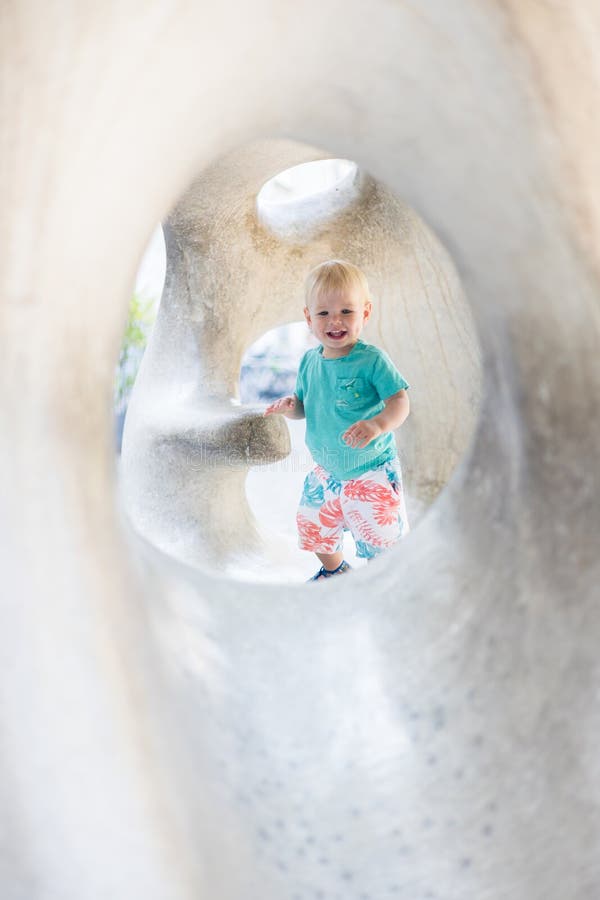 Giocare all'aperto. giochi per bambini in giardino scolastico o d'asilo. bambino attivo su scivolo di pietra fotografia stock libera da diritti