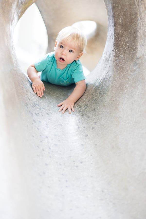 Giocare all'aperto. giochi per bambini in giardino scolastico o d'asilo. bambino attivo su scivolo di pietra fotografia stock