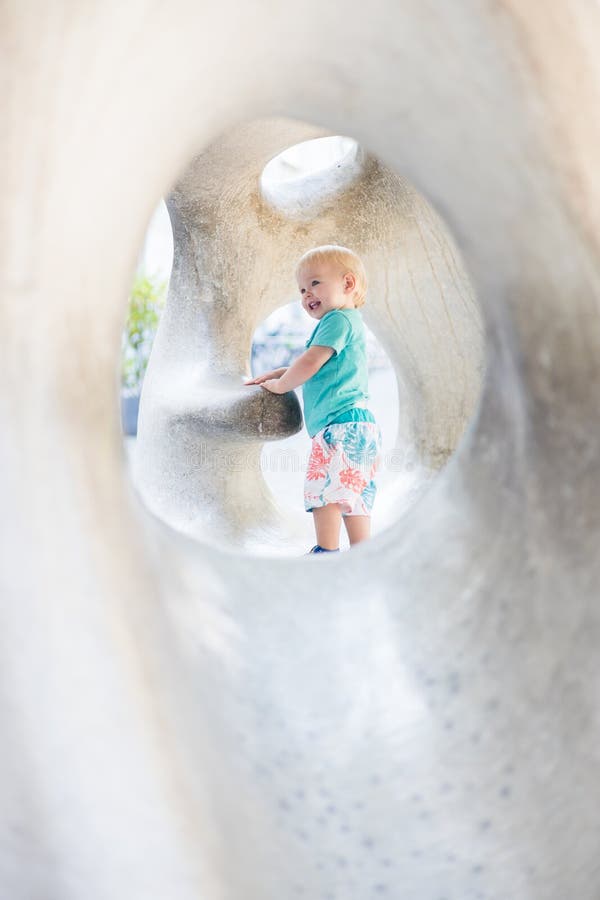 Giocare all'aperto. giochi per bambini in giardino scolastico o d'asilo. bambino attivo su scivolo di pietra fotografie stock
