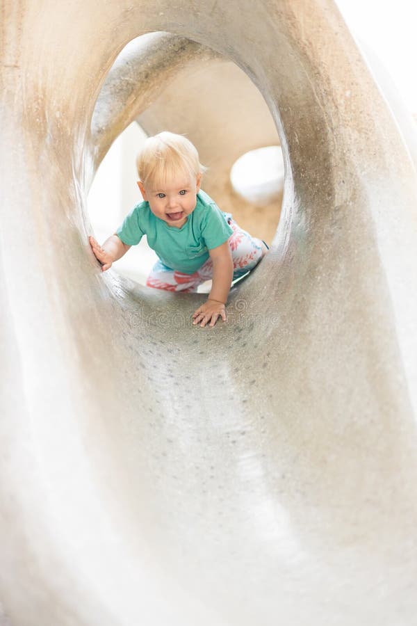 Giocare all'aperto. giochi per bambini in giardino scolastico o d'asilo. bambino attivo su scivolo di pietra fotografie stock libere da diritti