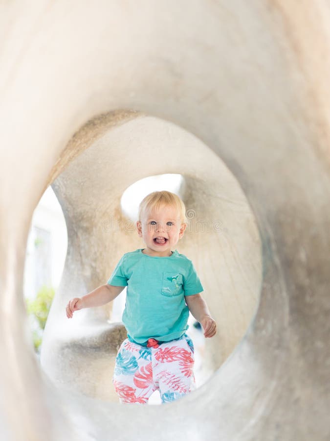 Giocare all'aperto. giochi per bambini in giardino scolastico o d'asilo. bambino attivo su scivolo di pietra fotografia stock libera da diritti