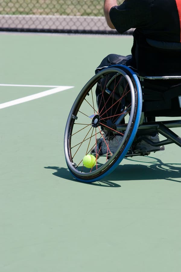 A wheelchair bound athlete on the tennis court - showing the angle of the wheel and the tennis ball being held in. A wheelchair bound athlete on the tennis court - showing the angle of the wheel and the tennis ball being held in