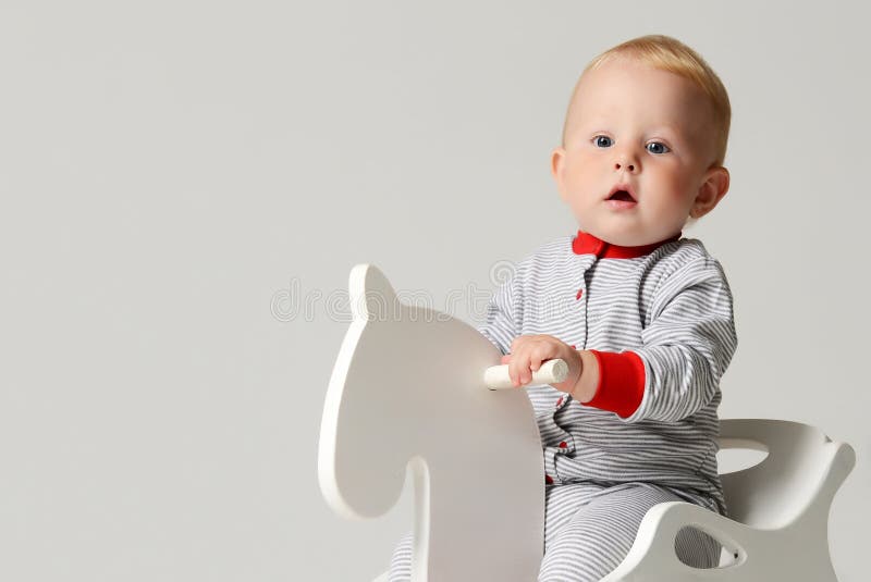 Giocattolo di legno bianco del cavallo del bambino del neonato del bambino del bambino di giro infantile di seduta piccolo fotografia stock libera da diritti Giocattolo di legno bianco del cavallo del bambino del neonato del bambino del bambino di giro infantile di seduta piccolo fotografia stock libera da diritti
