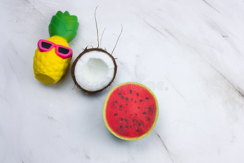 giocattolo divertente dell'ananas in occhiali da sole, anguria e noce di cocco su una tavola di marmo immagine stock giocattolo divertente dell'ananas in occhiali da sole, anguria e noce di cocco su una tavola di marmo immagine stock
