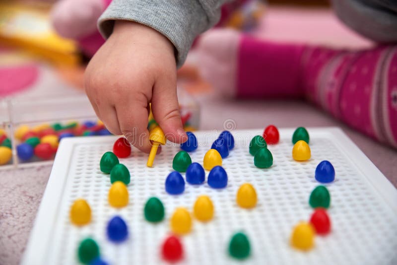 Giochi del bambino con i perni fotografia stock