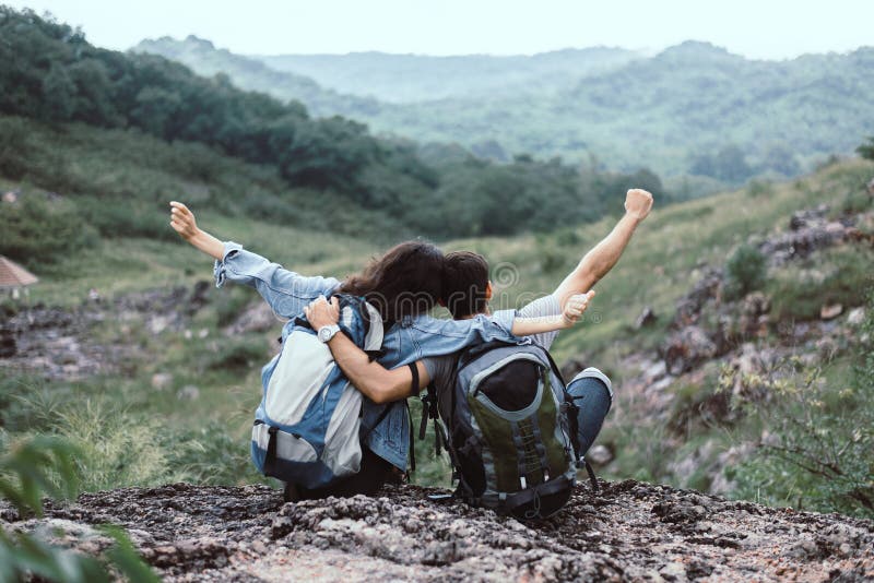 Giochiamo in campeggio in natura, Un'amante delle coppie seduta a mani alzate e una bella vista che si sente felice e sorride ins fotografia stock libera da diritti