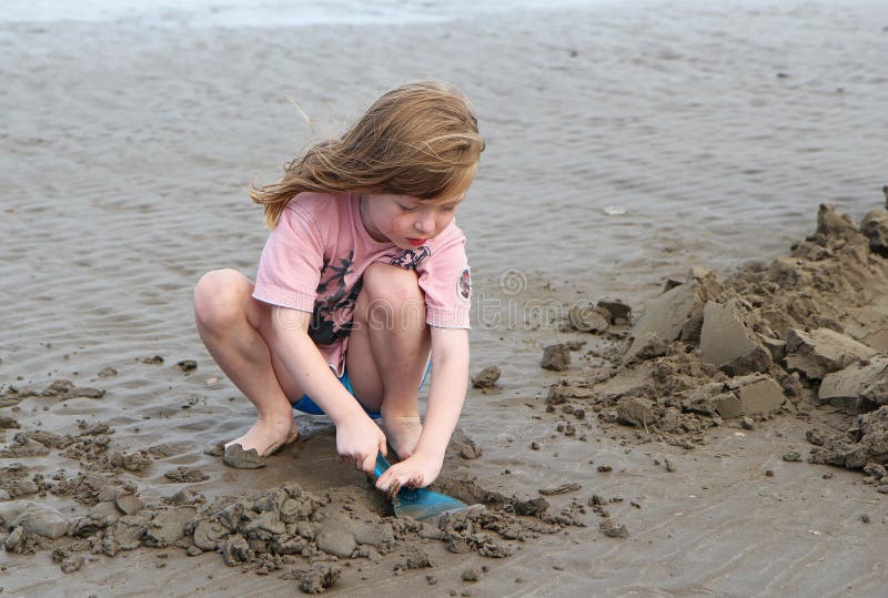 Gioco del bambino piccolo, facente i castelli di sabbia su una spiaggia immagine stock libera da diritti Gioco del bambino piccolo, facente i castelli di sabbia su una spiaggia immagine stock libera da diritti