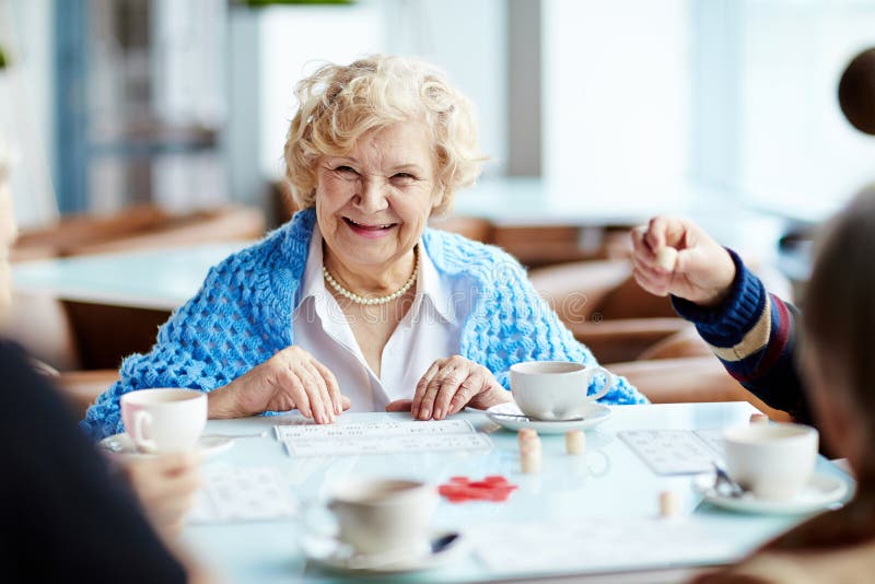 Gioco del lotto con gli amici senior fotografie stock libere da diritti Gioco del lotto con gli amici senior fotografie stock libere da diritti