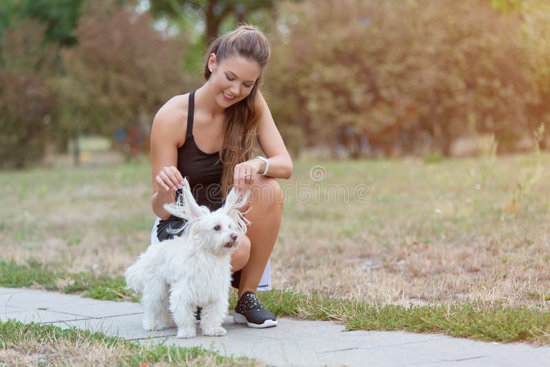 Gioco sveglio della donna con il suo cane immagine stock libera da diritti