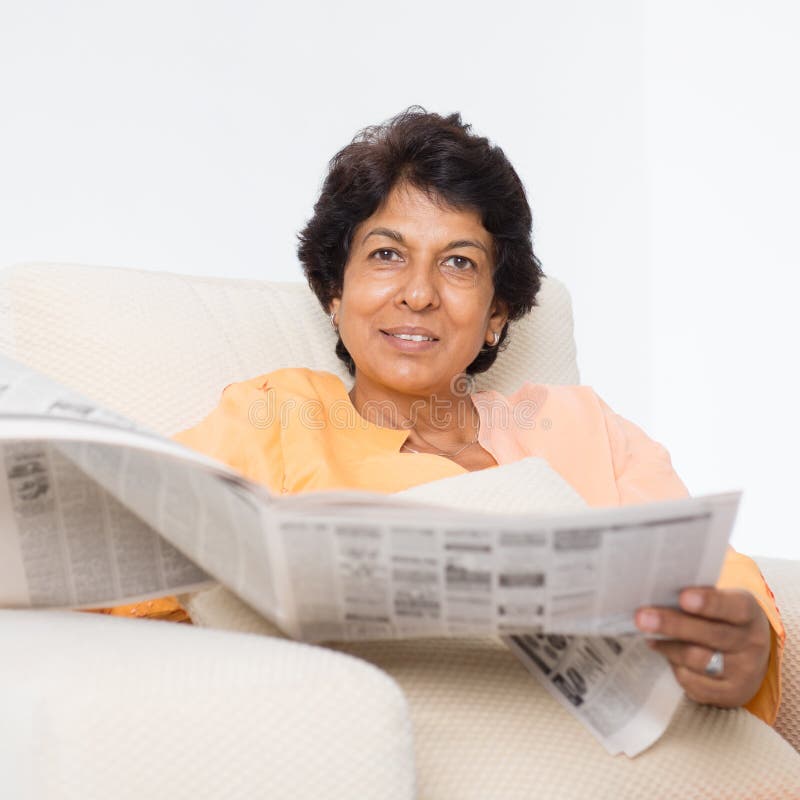 Giornale maturo indiano della lettura della donna immagini stock libere da diritti Giornale maturo indiano della lettura della donna immagini stock libere da diritti