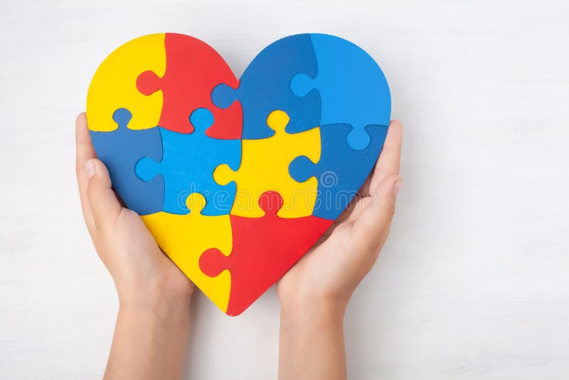 Giorno di consapevolezza di autismo del mondo, concetto mentale di sanità con il puzzle o modello del puzzle su cuore con le mani