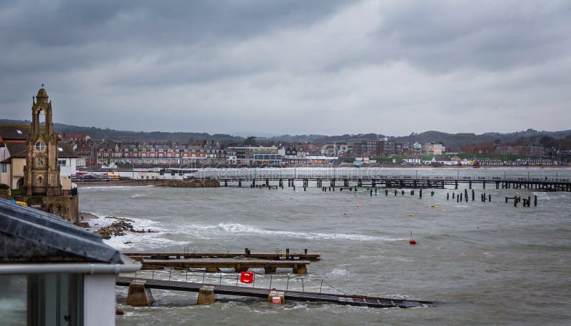 Giorno di inverni nuvoloso tempestoso alla spiaggia di Swanage in Dorset, il Regno Unito fotografia stock libera da diritti Giorno di inverni nuvoloso tempestoso alla spiaggia di Swanage in Dorset, il Regno Unito fotografia stock libera da diritti