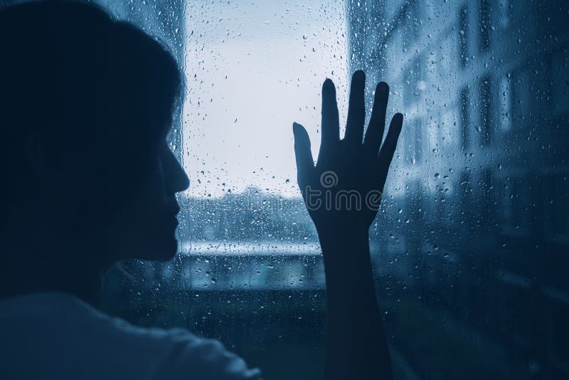 Giorno piovoso solo triste delle finestre di vetro di tocco della siluetta della donna di umore di depressione