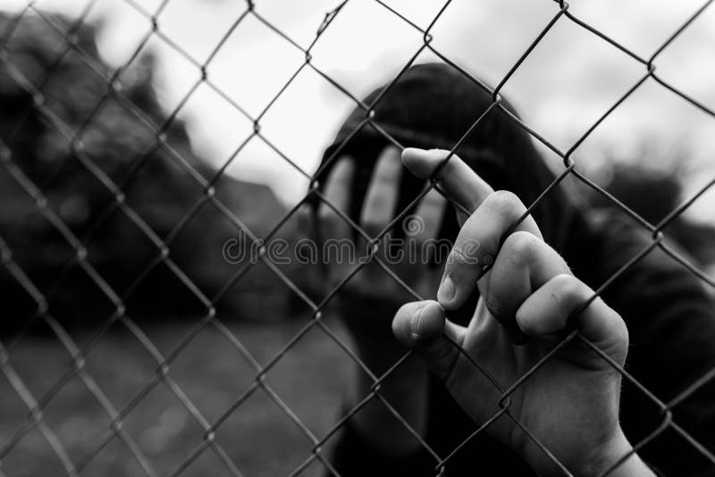 Giovane adolescente non identificabile che tiene il giardino metallico all'istituto correttivo, coprente il fronte dei hes fotografia stock libera da diritti Giovane adolescente non identificabile che tiene il giardino metallico all'istituto correttivo, coprente il fronte dei hes fotografia stock libera da diritti