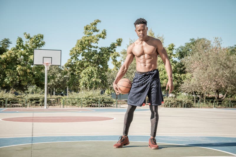Giovane afroamericano che gioca pallacanestro della via nel parco fotografia stock libera da diritti Giovane afroamericano che gioca pallacanestro della via nel parco fotografia stock libera da diritti