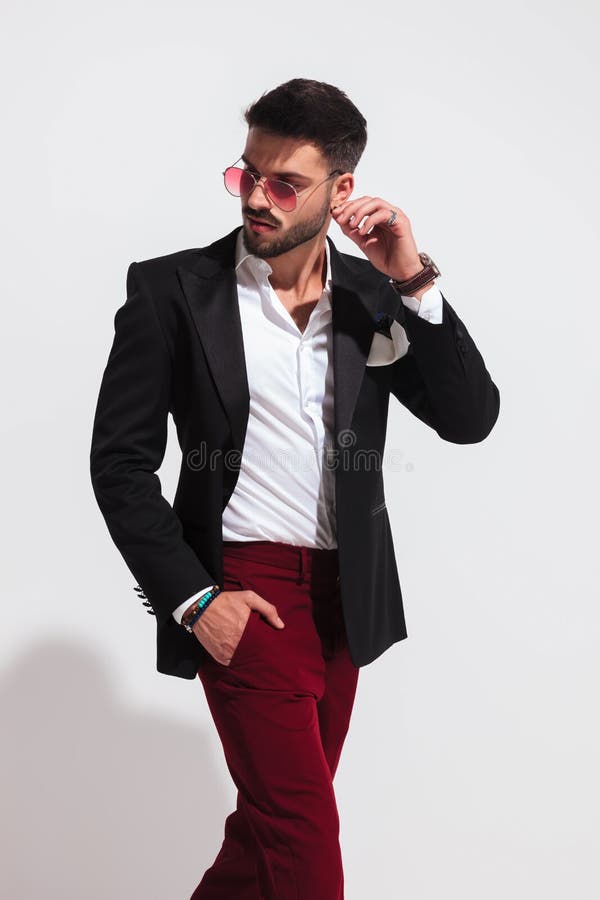 Giovane alla moda che fa un passo per parteggiare e che guarda dietro fotografie stock Giovane alla moda che fa un passo per parteggiare e che guarda dietro fotografie stock