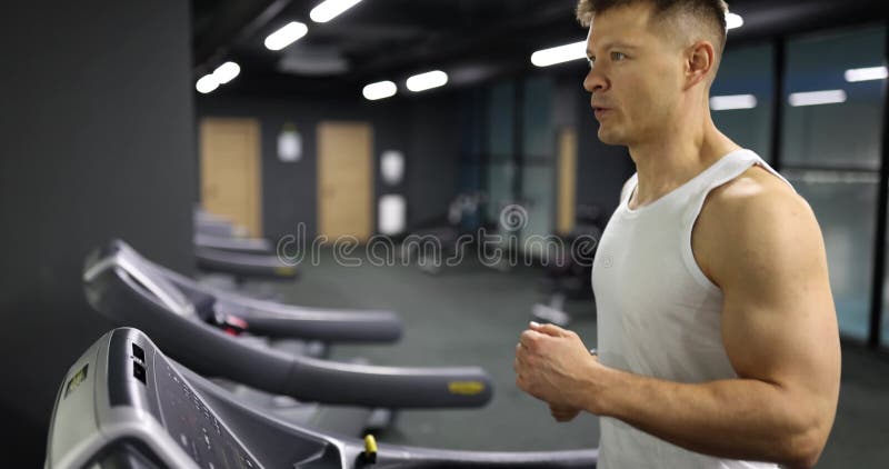 Giovane atleta in palestra e corre su tapis roulant