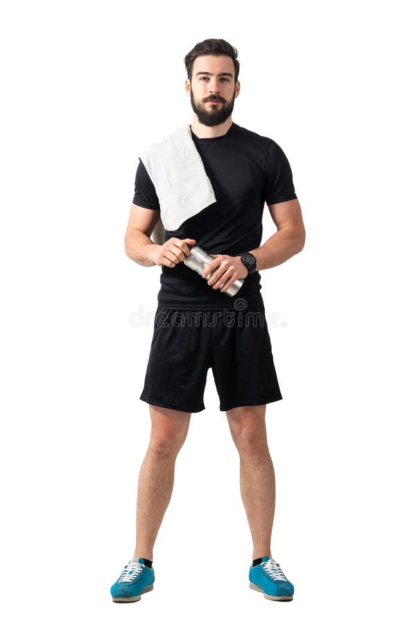 Giovane atleta sicuro con l'asciugamano e la bottiglia che esaminano macchina fotografica immagini stock libere da diritti Giovane atleta sicuro con l'asciugamano e la bottiglia che esaminano macchina fotografica immagini stock libere da diritti