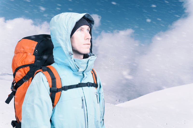 Giovane avventuroso con lo zaino che sta sulla vista superiore della montagna e che guarda fuori Alpinismo, sport estremo immagine stock Giovane avventuroso con lo zaino che sta sulla vista superiore della montagna e che guarda fuori Alpinismo, sport estremo immagine stock