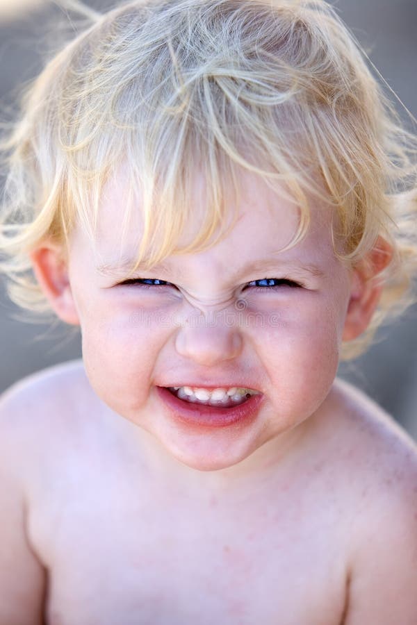 Giovane bambino femminile o bambino con il grin insolente sul suo fronte immagini stock