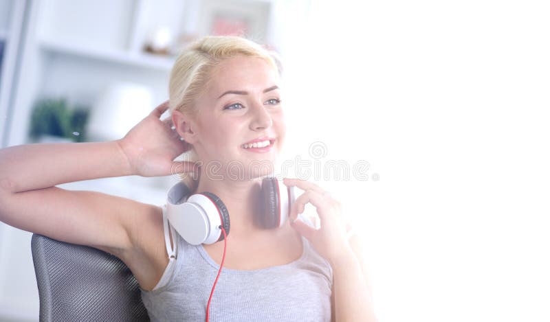 Giovane bella donna a casa che si siede sul sof? e sulla musica d'ascolto fotografia stock Giovane bella donna a casa che si siede sul sof? e sulla musica d'ascolto fotografia stock