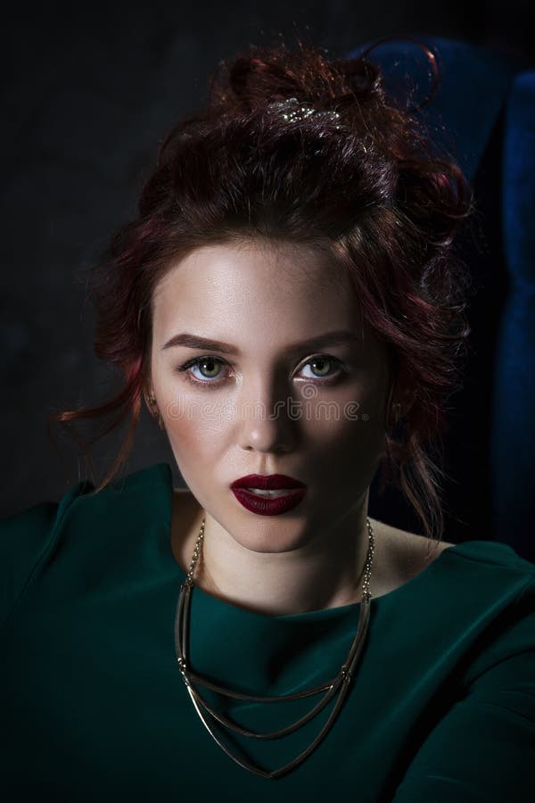 Giovane bella donna caucasica dai capelli rossi con trucco professionale in vestito verde fotografia stock Giovane bella donna caucasica dai capelli rossi con trucco professionale in vestito verde fotografia stock