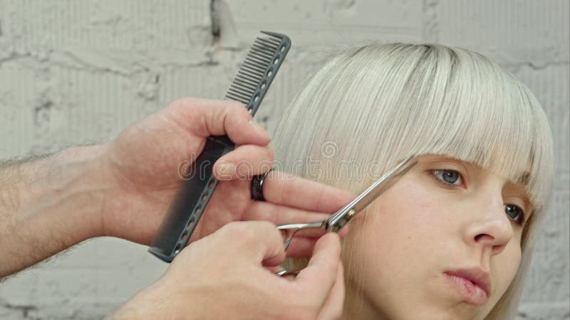 Giovane bella donna che fa i suoi tagliare capelli al ` s del parrucchiere