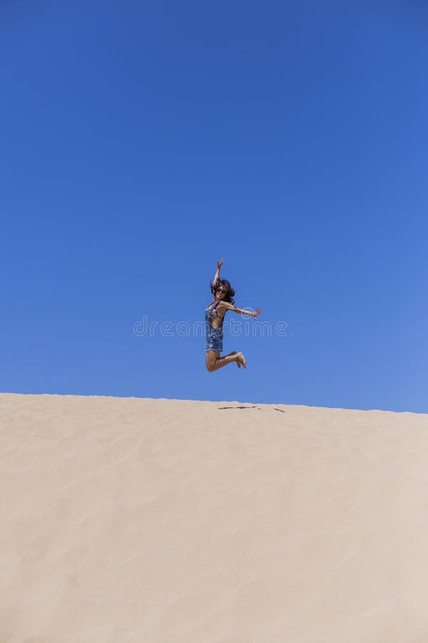 giovane bella donna che salta sulle dune nel Portogallo Estate, divertimento e concetto di feste fotografie stock libere da diritti giovane bella donna che salta sulle dune nel Portogallo Estate, divertimento e concetto di feste fotografie stock libere da diritti
