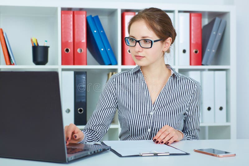 Giovane bella donna di affari che lavora ad un computer portatile nell'ufficio Affare, mercato dei cambi, offerta di lavoro, anal fotografia stock Giovane bella donna di affari che lavora ad un computer portatile nell'ufficio Affare, mercato dei cambi, offerta di lavoro, anal fotografia stock