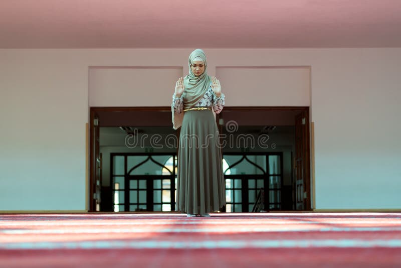 Giovane bella donna musulmana che prega nella moschea fotografia stock libera da diritti Giovane bella donna musulmana che prega nella moschea fotografia stock libera da diritti