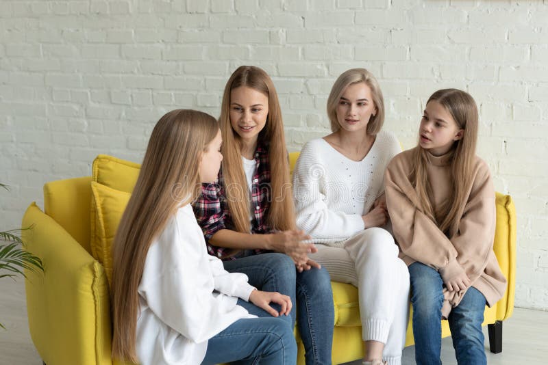 Giovane bella famiglia lesbica in abbigliamento casual che si siede sul sof? giallo a casa fotografia stock libera da diritti Giovane bella famiglia lesbica in abbigliamento casual che si siede sul sof? giallo a casa fotografia stock libera da diritti
