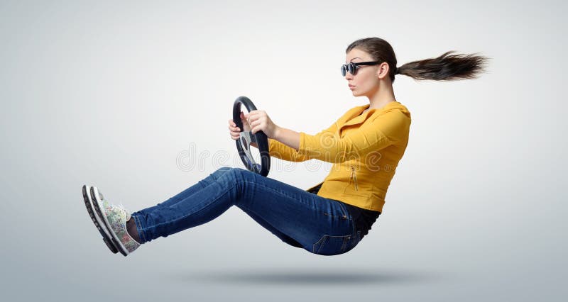 Giovane bella ragazza in automobile dell'autista degli occhiali da sole con una ruota immagine stock Giovane bella ragazza in automobile dell'autista degli occhiali da sole con una ruota immagine stock