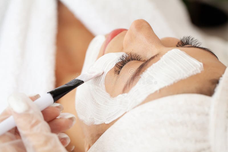 Giovane bella ragazza che indossa mascherine nel salone di bellezza delle terme fotografie stock