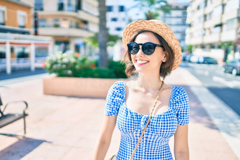 Giovane bella ragazza che sorride felice camminando per strada in città fotografia stock