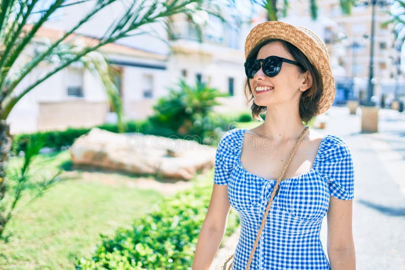 Giovane bella ragazza che sorride felice camminando per strada in città fotografia stock