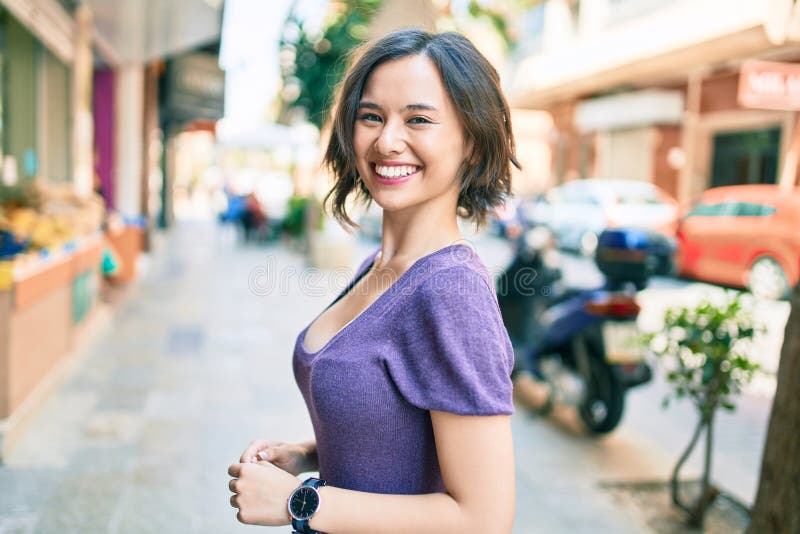 Giovane bella ragazza che sorride felice camminando per strada in città immagini stock libere da diritti