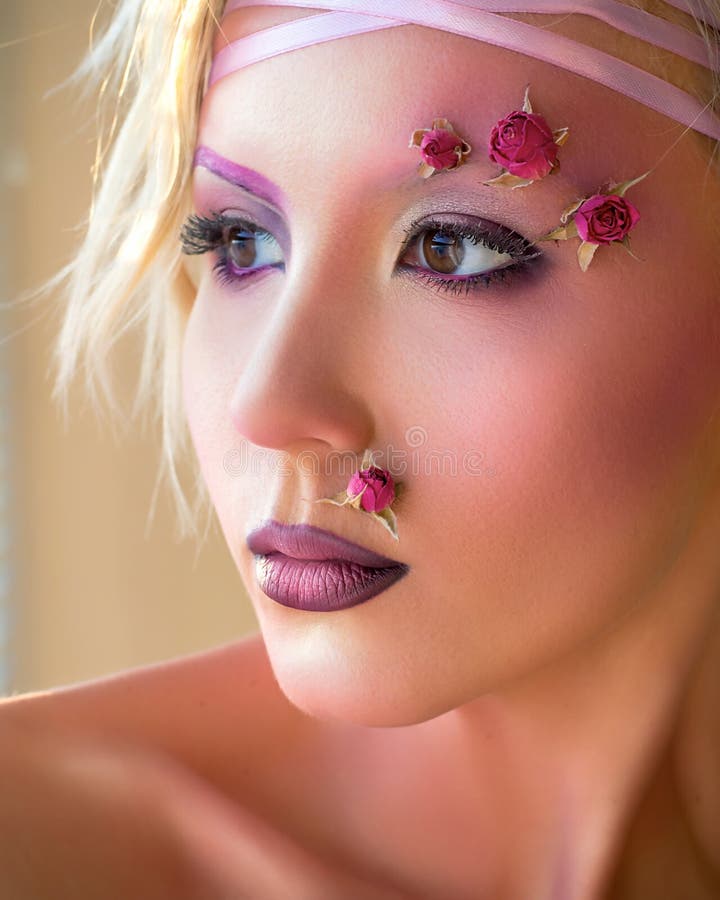 Giovane bella ragazza, trucco porpora alla moda e rose sul fronte immagini stock Giovane bella ragazza, trucco porpora alla moda e rose sul fronte immagini stock