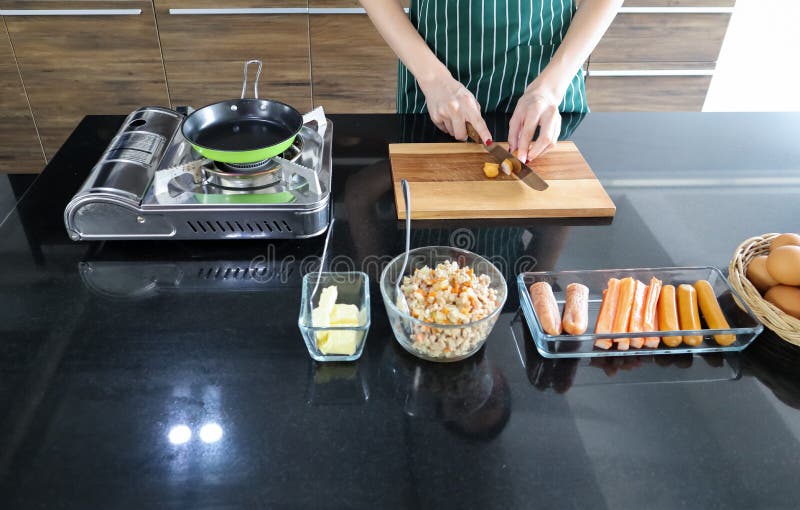 Giovane bella salsiccia asiatica delle fette della donna sul piatto di legno sulla tavola di marmo nera anche con le uova, il bur fotografie stock libere da diritti Giovane bella salsiccia asiatica delle fette della donna sul piatto di legno sulla tavola di marmo nera anche con le uova, il bur fotografie stock libere da diritti