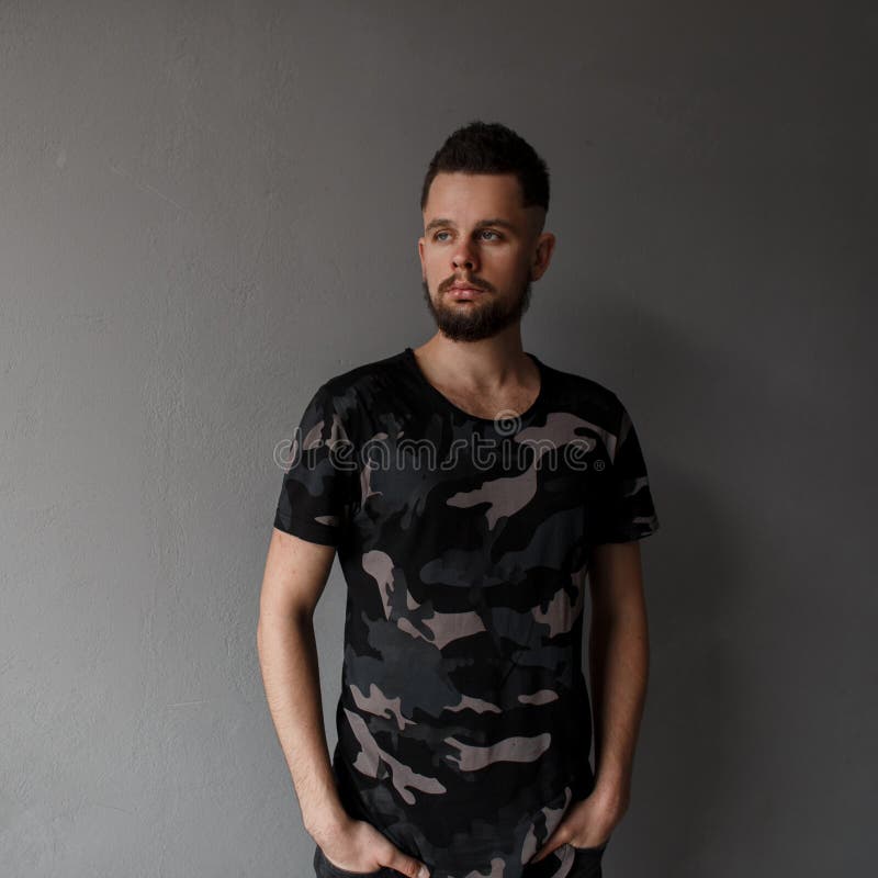 Giovane bello con un'acconciatura alla moda e una barba brutale immagine stock libera da diritti