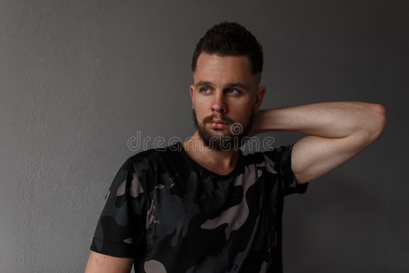 Giovane bello con un'acconciatura alla moda e una barba brutale fotografie stock libere da diritti