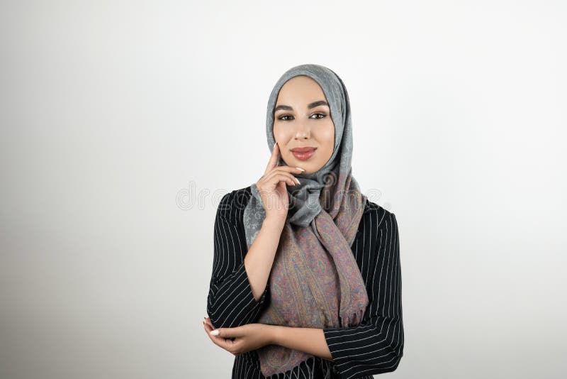 Giovane bello foulard d'uso musulmano del hijab del turbante della donna di affari che tocca il suo fronte con una mano nella con fotografia stock libera da diritti Giovane bello foulard d'uso musulmano del hijab del turbante della donna di affari che tocca il suo fronte con una mano nella con fotografia stock libera da diritti