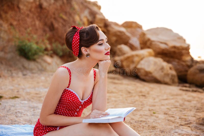 Giovane bello perno pensieroso sulla ragazza che si siede con il libro immagine stock Giovane bello perno pensieroso sulla ragazza che si siede con il libro immagine stock