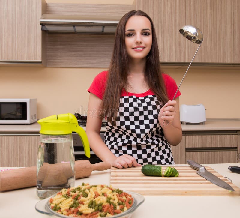 Giovane casalinga che lavora in cucina fotografie stock