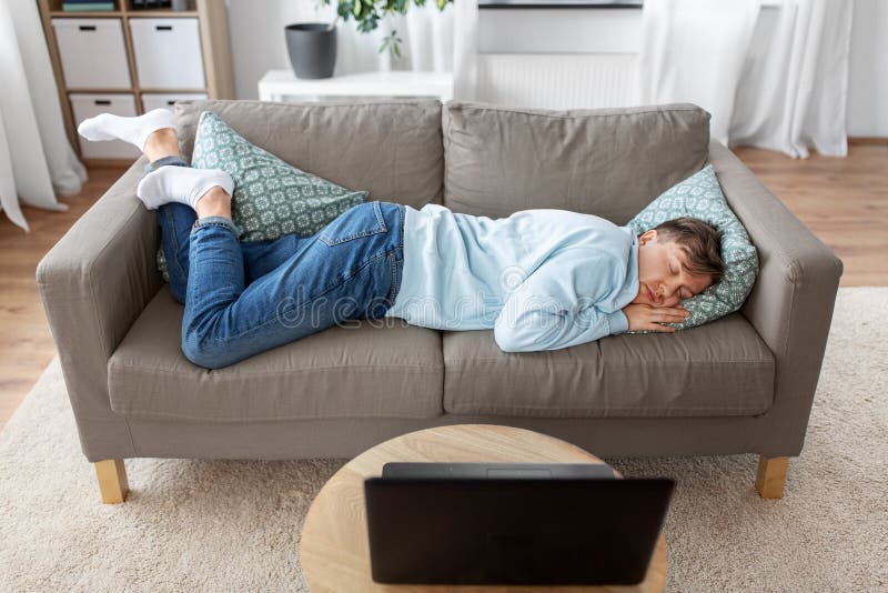 people, boredom and depression concept - lazy young man sleeping on sofa at home. people, boredom and depression concept - lazy young man sleeping on sofa at home