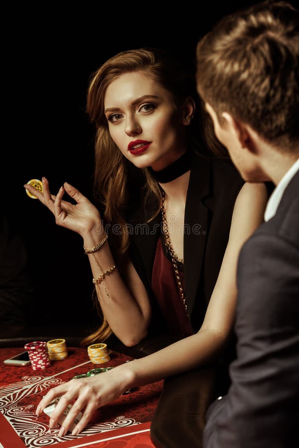 Giovane che esamina donna splendida con il chip di mazza in casinò fotografie stock Giovane che esamina donna splendida con il chip di mazza in casinò fotografie stock